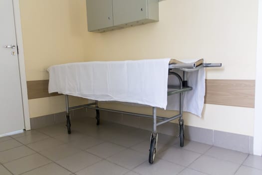 Photo of empty stretcher in hospital corridor