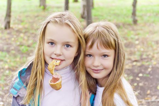 Photo of cute two eating blond girls