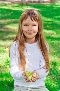 Photo of cute girl with apples in summer