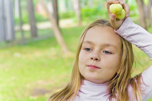 Photo of cute girl with apples in summer