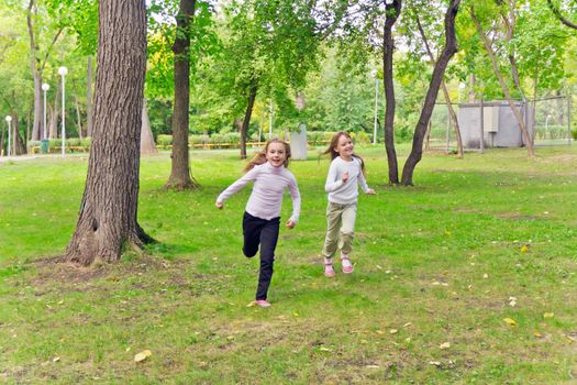 Photo of two running girls in summer