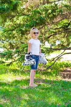 Photo of smiling girl playing with roll skates 