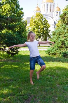Cute girl with blond hair jumping on one leg
