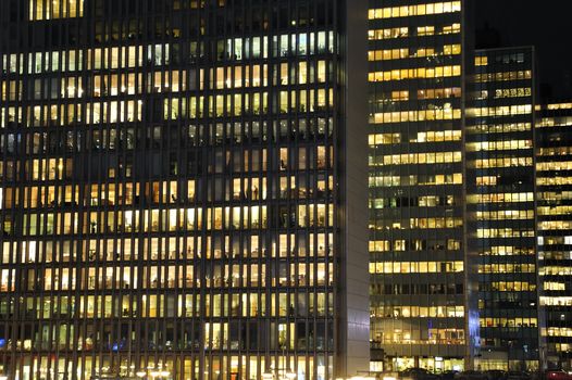 Workers working late. Office windows by night.