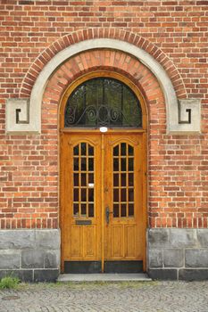 Exterior door shot vertically surrounded by a residential brick wall.