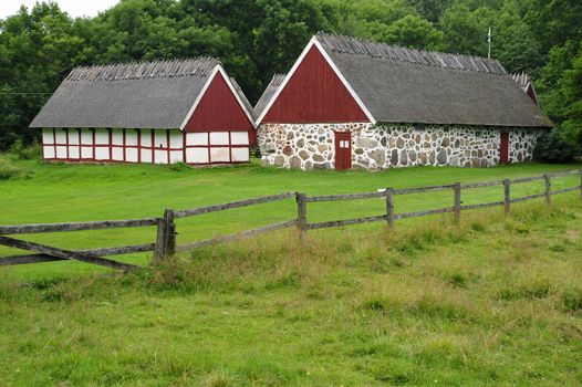 Old well kept red and white barn with a green field surrounding it, Mölle in Sweden.
