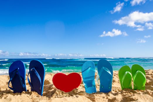 Flip flops with heart shape on the sandy beach in Hawaii, Kauai (romantic concept)