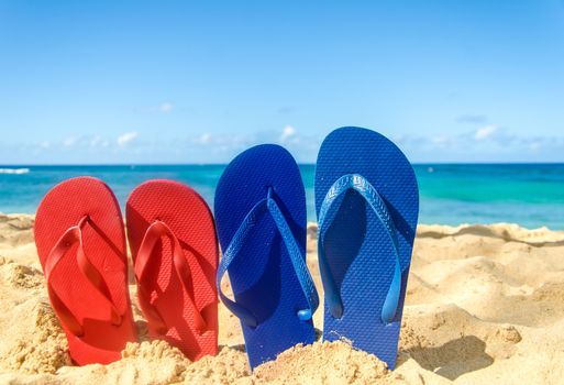 Blue and red flip flops on the sandy beach in Hawaii, Kauai