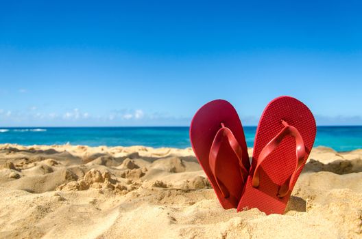 Red flip flops in heart shape on the sandy beach in Hawaii, Kauai (romantic concept)
