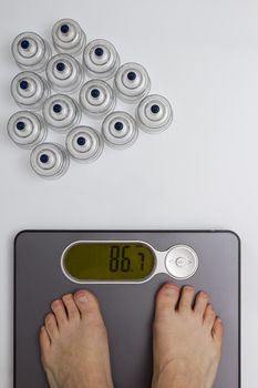 Men's feet on floor scales and medical cans for vacuum massage.