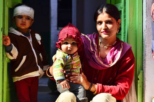 Jodhpur, India - January 1, 2015: Indian proud mother poses with her children in Jodhpur, India. Jodhpur is the second largest city in the Indian state of Rajasthan with over 1 million habitants.