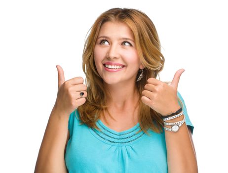 Young woman is showing thumb up gesture, isolated over white
