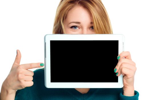 Young cheerful woman is showing blank tablet, isolated over white