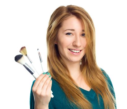 Girl is applying makeup using brush, isolated over white