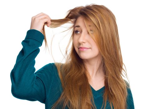 Young woman holding damaged long hair the hand and looking at split ends, isolated on white background
