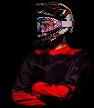 Cyclist man in bicycle uniform with crossed arms on black background