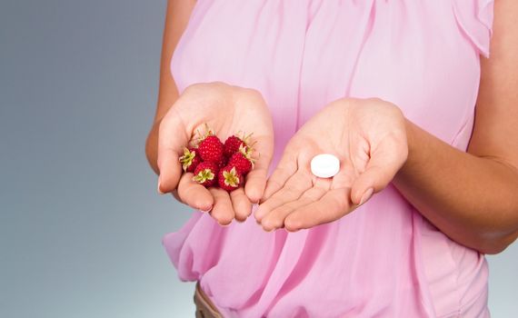 Woman hold on palm raspberries and tablet