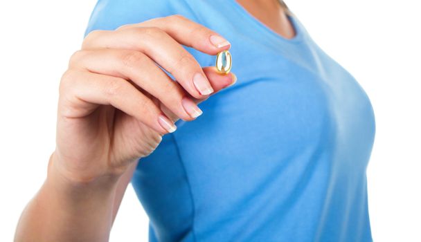 Closeup picture of woman with Omega 3 fish oil capsule isolated over white