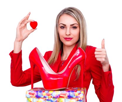 Young beautiful woman happy to receive red high heels shoes as a present and showing thumb up gesture, isolated on white
