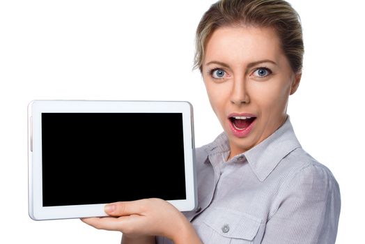 Young cheerful surprised woman is showing blank tablet, isolated over white
