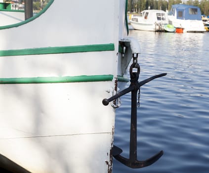 An anchor hanging on a boat in harbor