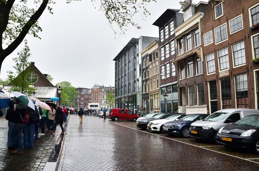 Amsterdam, Netherlands - May 16, 2015: Tourists queuing at the Anne Frank house and holocaust museum in Amsterdam, Netherlands, on May 16, 2015. Anne Frank house is a popular tourist destination.