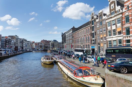 Amsterdam, Netherlands - May 7, 2015: Passenger boats on canal tour in the city of Amsterdam on May 7, 2015. Amsterdam is the capital and most populous city of the Netherlands.