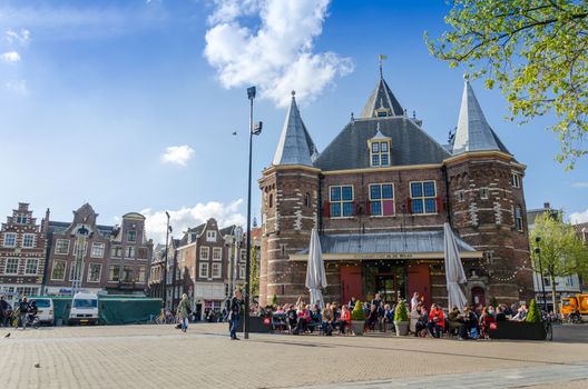 Amsterdam, Netherlands - May 7, 2015: People visit The Waag (weigh house) on Nieuwmarkt square in Amsterdam. It was originally a city gate and part of the walls of Amsterdam.