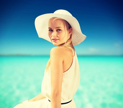 fashion and lifestyle concept - beautiful woman in hat enjoying summer outdoors