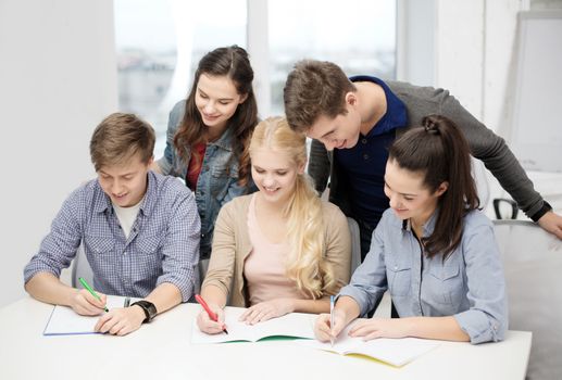 school and education concept - group of smiling students with notebooks at school