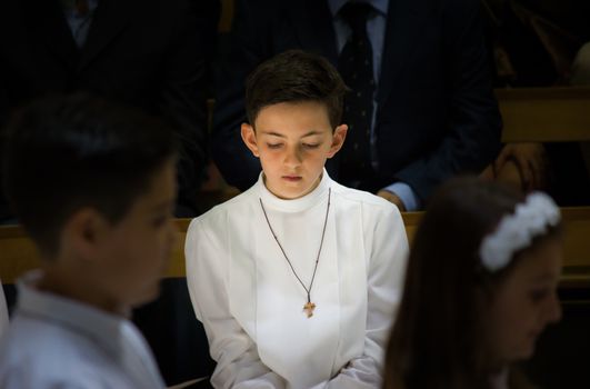 a child receiving the religious sacrament of the first communion