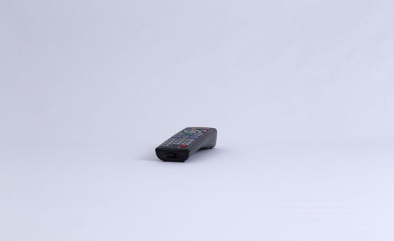 An isolated TV remote control facing direction towards you.