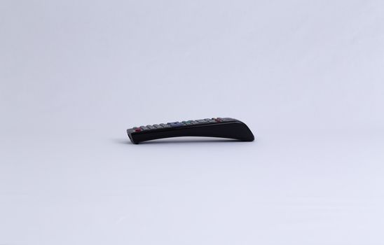 An isolated remote control from the side  for tv or other electronical equipment