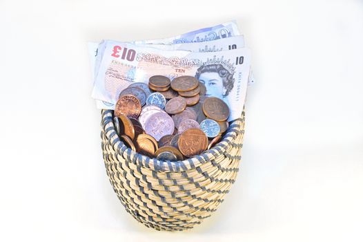 coins in basket and british banknotes