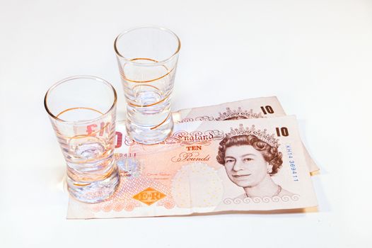 two vodka glasses on banknotes ten pounds