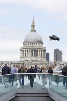 LONDON, UK - JUNE 23: Dome of Saint Paul's cathedral, with people crossing Millennium Bridge in the foreground. June 23, 2015 in London.