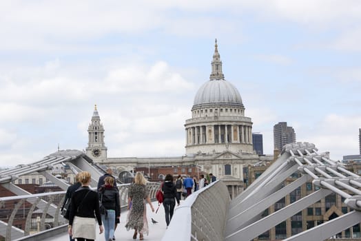 LONDON, UK - JUNE 23: Dome of Saint Paul's cathedral, with people crossing Millennium Bridge in the foreground. June 23, 2015 in London.