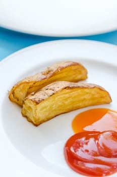 Roasted or baked potatoes with tomato and chili sauce