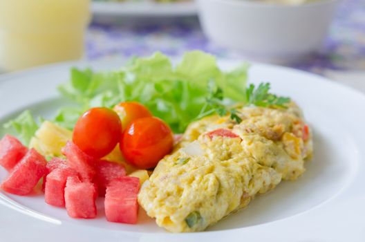A breakfast , omlette with mix fruit salad