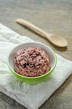 Cooked rice of Riceberry in green bowl on wooden table