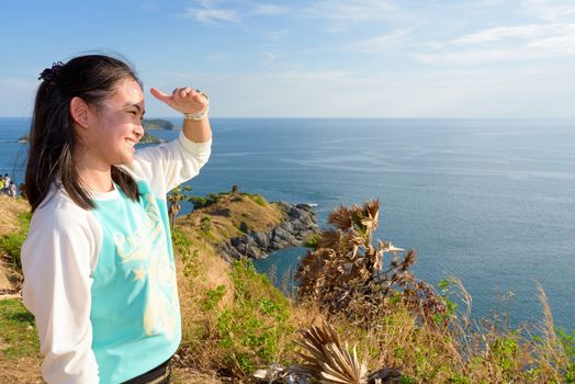 Women tourist looking beautiful nature sea and island with a happy smile after success from efforts to come up to viewpoint at Laem Phromthep Cape a famous attractions of Phuket Province in Thailand