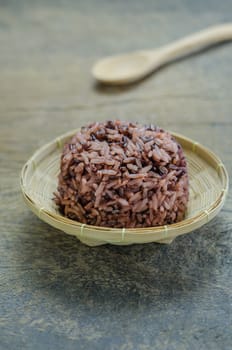 Cooked rice of Riceberry in bamboo basket  on wooden table