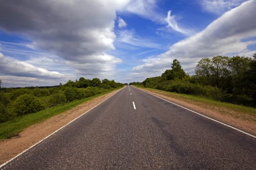   the small rural asphalted road photographed in summertime of year. Belarus