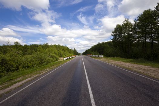  the small rural asphalted road photographed in summertime of year. Belarus