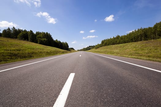   the small rural asphalted road photographed in summertime of year. Belarus