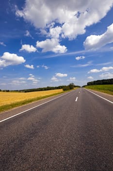   the small rural asphalted road photographed in summertime of year. Belarus