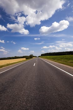  the small rural asphalted road photographed in summertime of year. Belarus