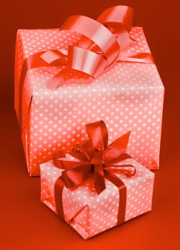 Two Gift Polka Dot Boxes with Bow isolated on Red background. Toned