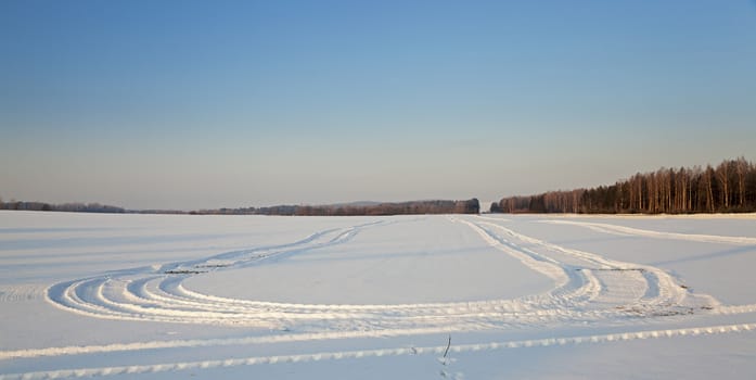  the rural road in an agricultural field in a winter season