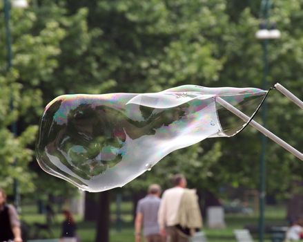 Giant soap bubbles created with ropes and sticks in a park
